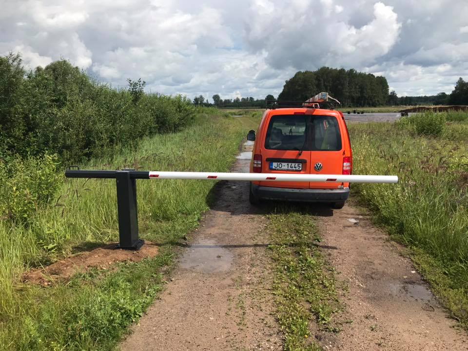 closed barrier boom lowered in a field ripo bright orange car